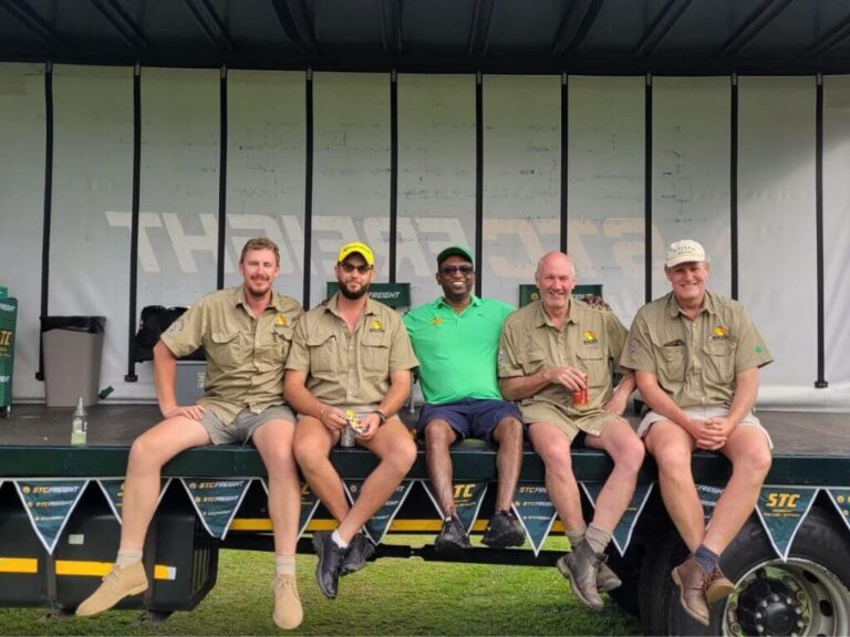 Group of five men, sitting and smiling on an STC vehicle at the Annual Citrus Growers Charity Golf Day.